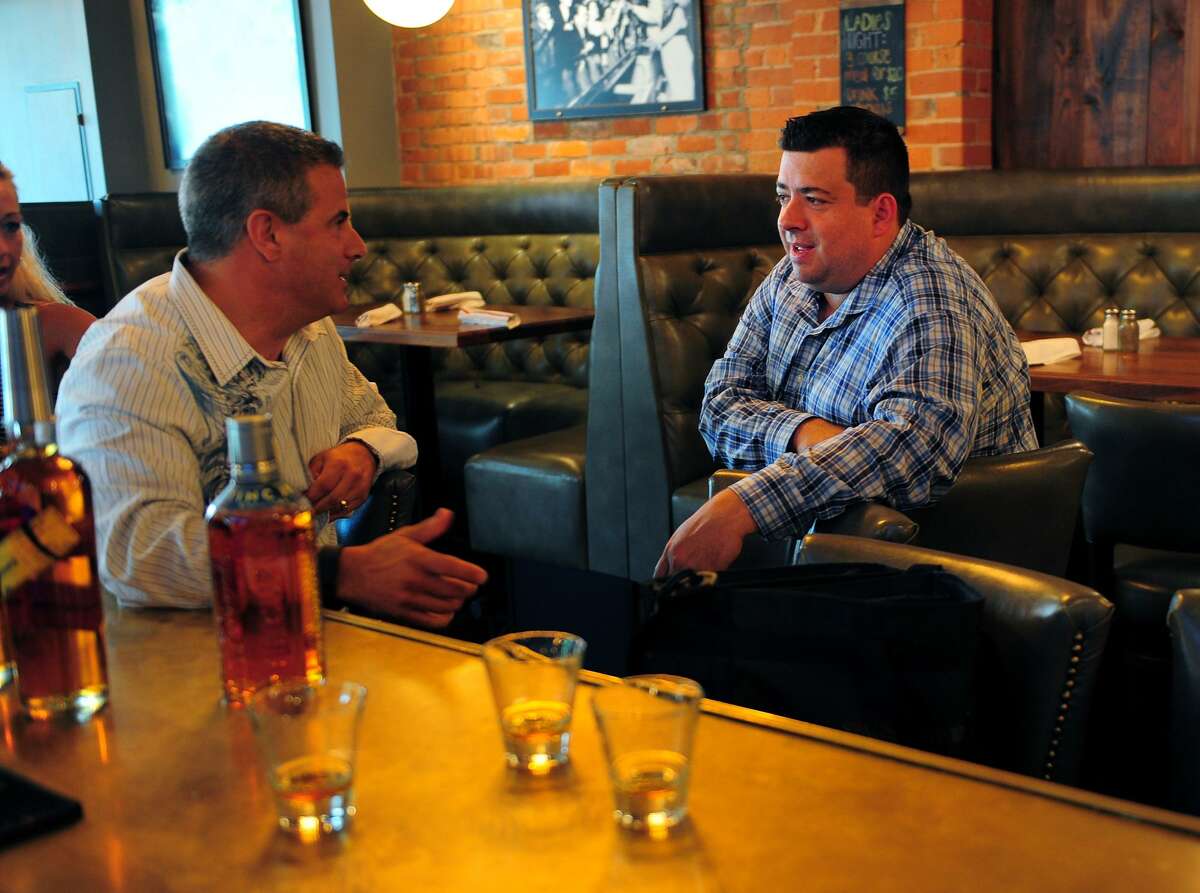 Eli’s Tavern General Manager Kevin Fitzsimmons, right, chats with Proximo Spirits sales rep Ray Cruciani, at the restaurant on Daniel Street in Milford in 2015. On Wednesday, Eli’s marked the 100th anniversary of Prohibition with happy hour speakeasy cocktails.