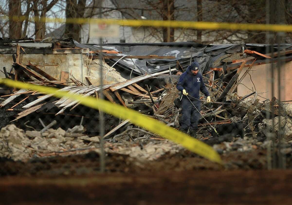 A dog sniffs through the burned wreckage during the ongoing fire investigation at the Shakespeare Theater site in Stratford, Conn. on Wednesday, January 16, 2019. The theater was destroyed by fire early Sunday morning.