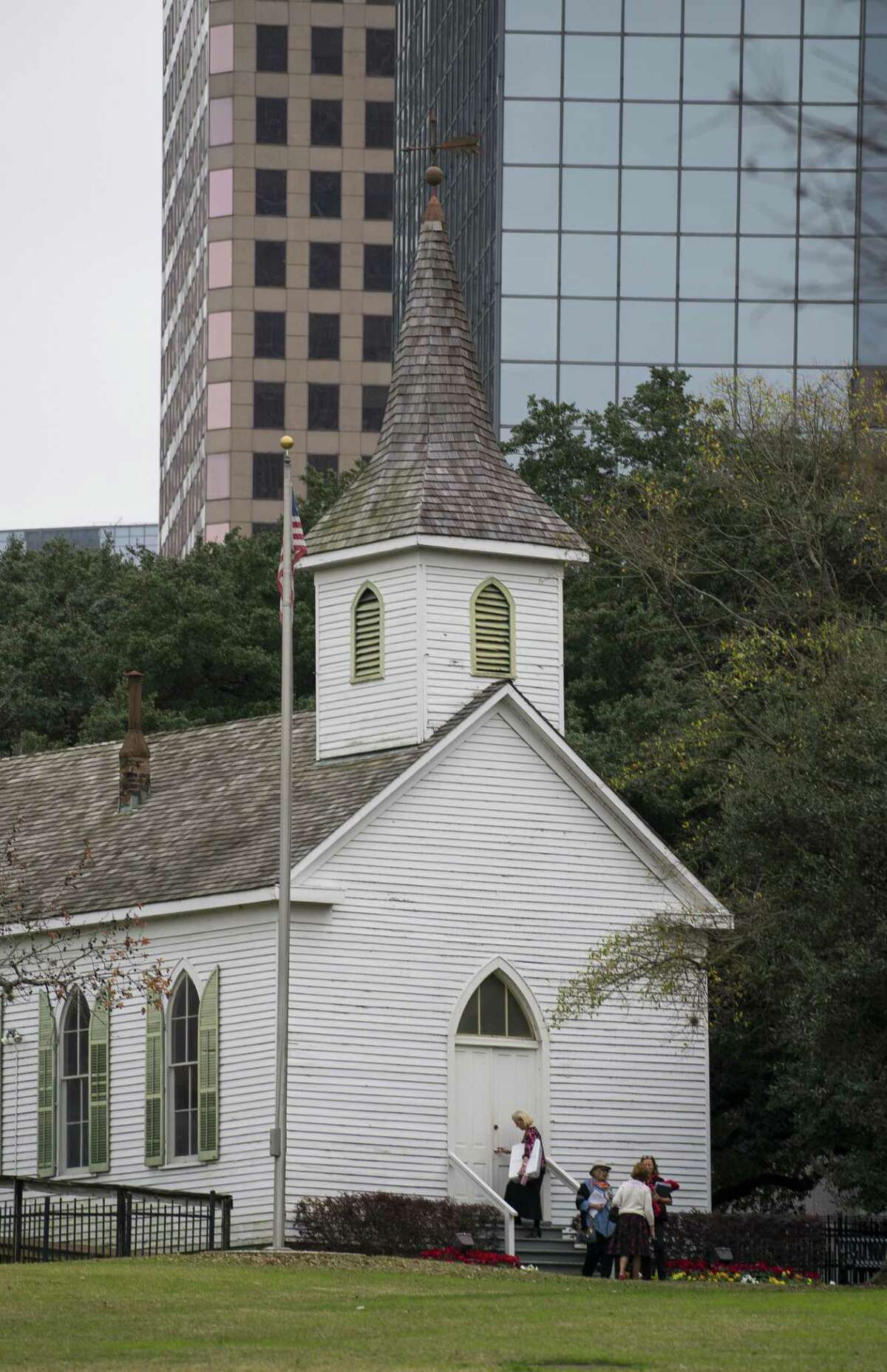 People exit the St. John Church building, originally built in 1891, and now standing in Sam Houston Park in downtown Houston where historic buildings are maintained by the Heritage Society.