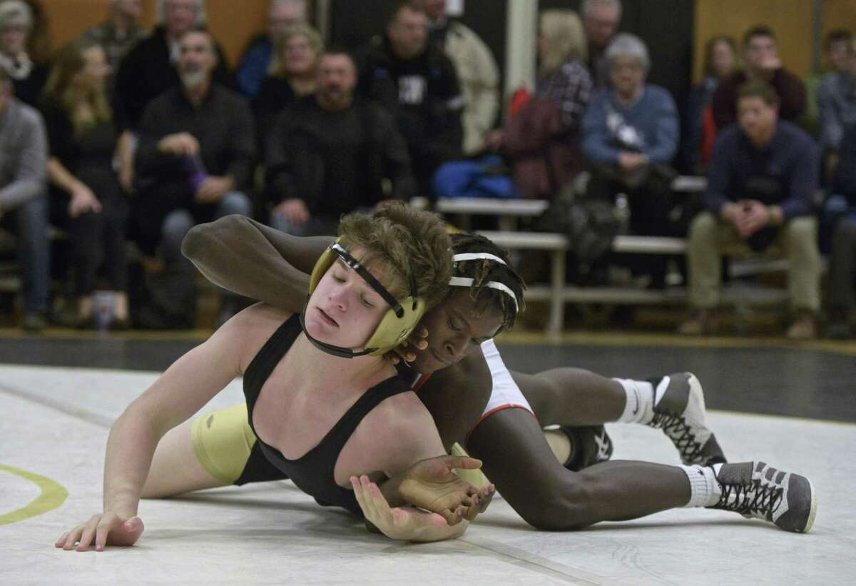 Trumbull's Ben Cousins, in black, and Danbury's Tyrell Jones, in white, wrestle in the 160 pound weight class during a match between Danbury and Trumbull high schools, Wednesday, January 16, 2019, at Trumbull High School, in Trumbull, Conn.