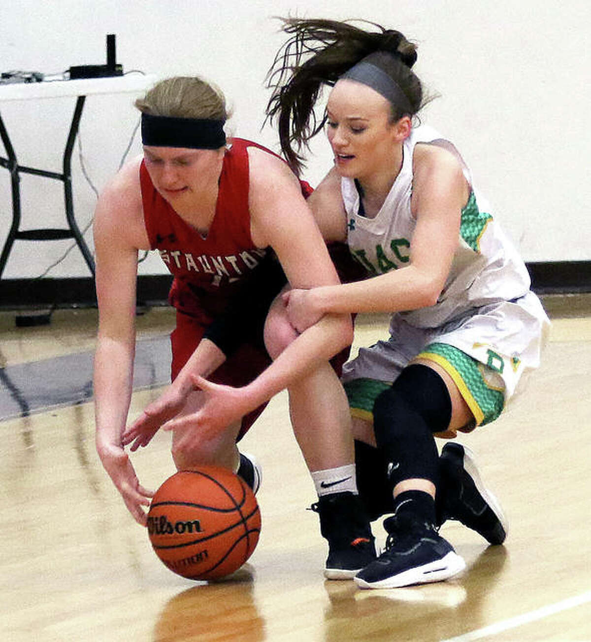 Staunton’s Rebecca Caldieraro (left) and Southwestern’s Abbey Burns battle for a loose ball in the second half of Wednesday night’s semifinal at the Macoupin County Tournament in Mount Olive.