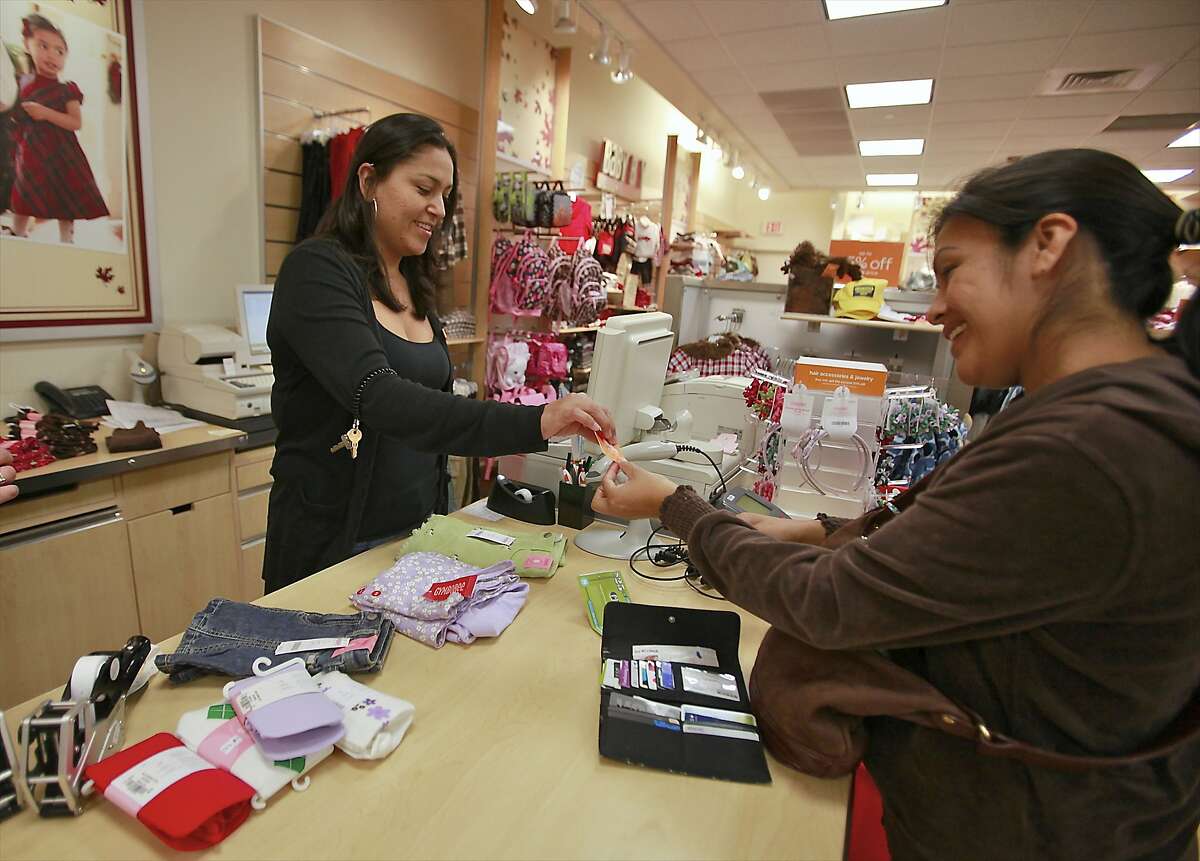 FILE - In this Monday, Oct. 4, 2010, file photo, Susi Ortiz, right, buys children's clothing at the Gymboree store at the Westside Pavilion Shopping Center in Los Angeles. Children’s clothing retailer Gymboree has filed bankruptcy protection for a second time in as many years and will begin winding down all operations. The San Francisco company said late Wednesday, Jan. 17, 2019, that it will close all of its Gymboree and Crazy 8 stores, and will to sell its Janie and Jack business, intellectual property and online business. (AP Photo/Damian Dovarganes, File)