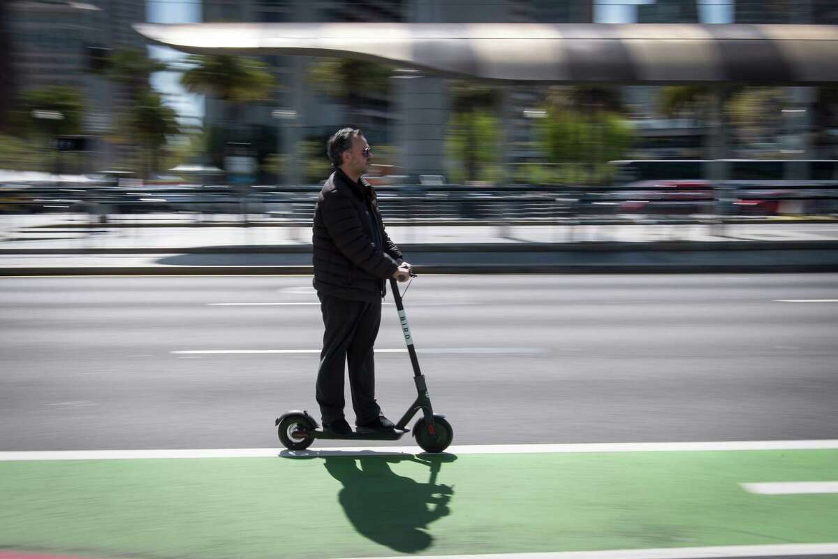 A person rides a Bird Rides shared electric scooter on the Embarcadero in San Francisco, California, on April 13, 2018.