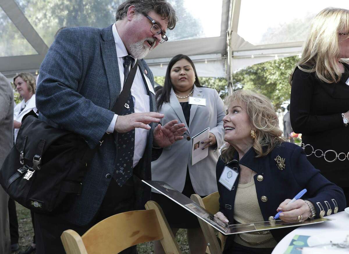 Vikki Carr, right, signs a record album for Stephen Ray, Texas Music Office Program Specialist, after Carr was inducted into the Texas Women's Hall of Fame at the Governor's Mansion in Austin, on Thursday, Jan. 17, 2019.