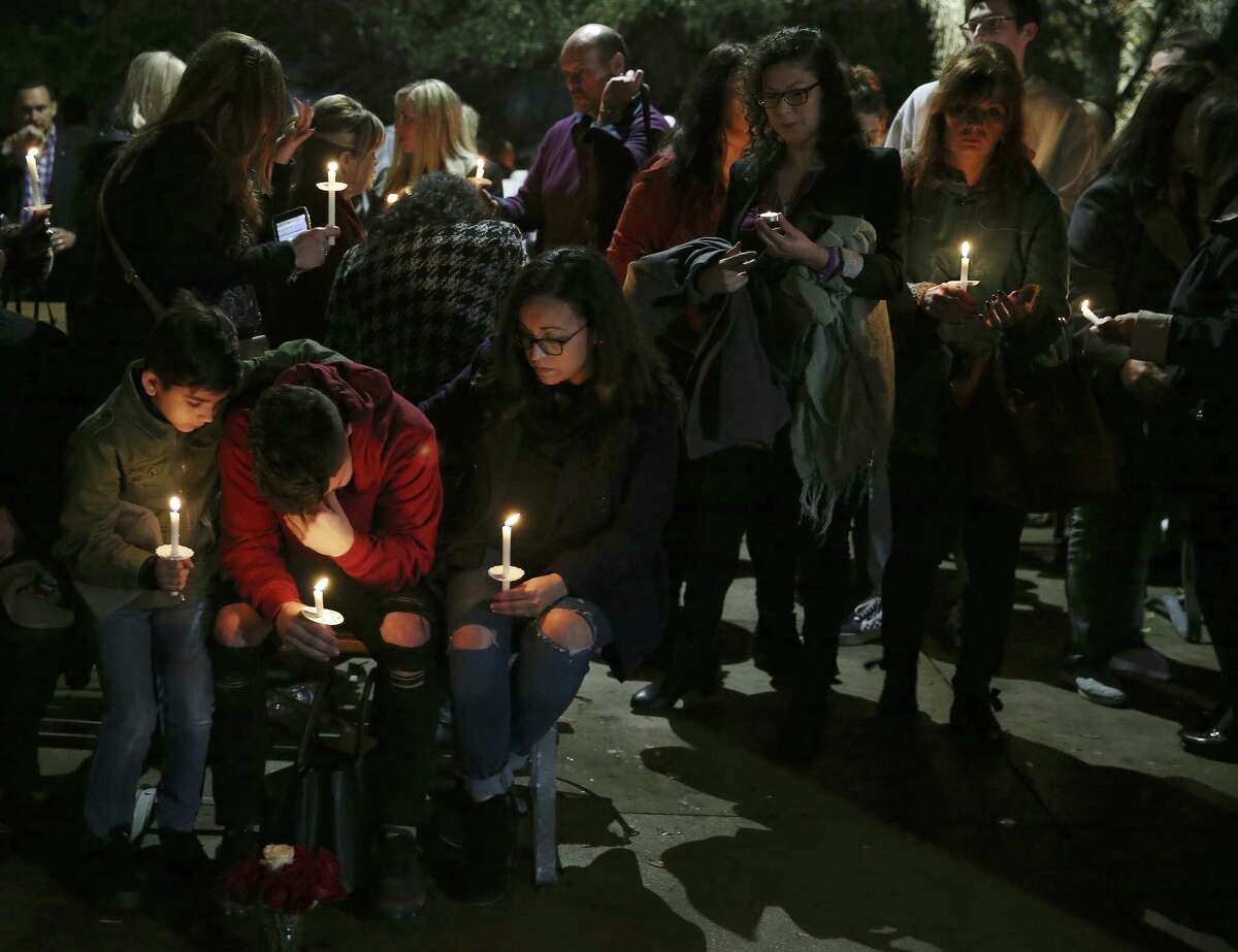 Friends and family gather for a vigil honoring Nichol Olsen and her two daughters at the Oblate Mission Lourdes Grotto on Wednesday. Olsen, 37, and her two daughters, Alexa Denice Montez, 16, and London Sophia Bribiescas, 10, were found shot to death at a home in a gated community near Leon Springs last week.