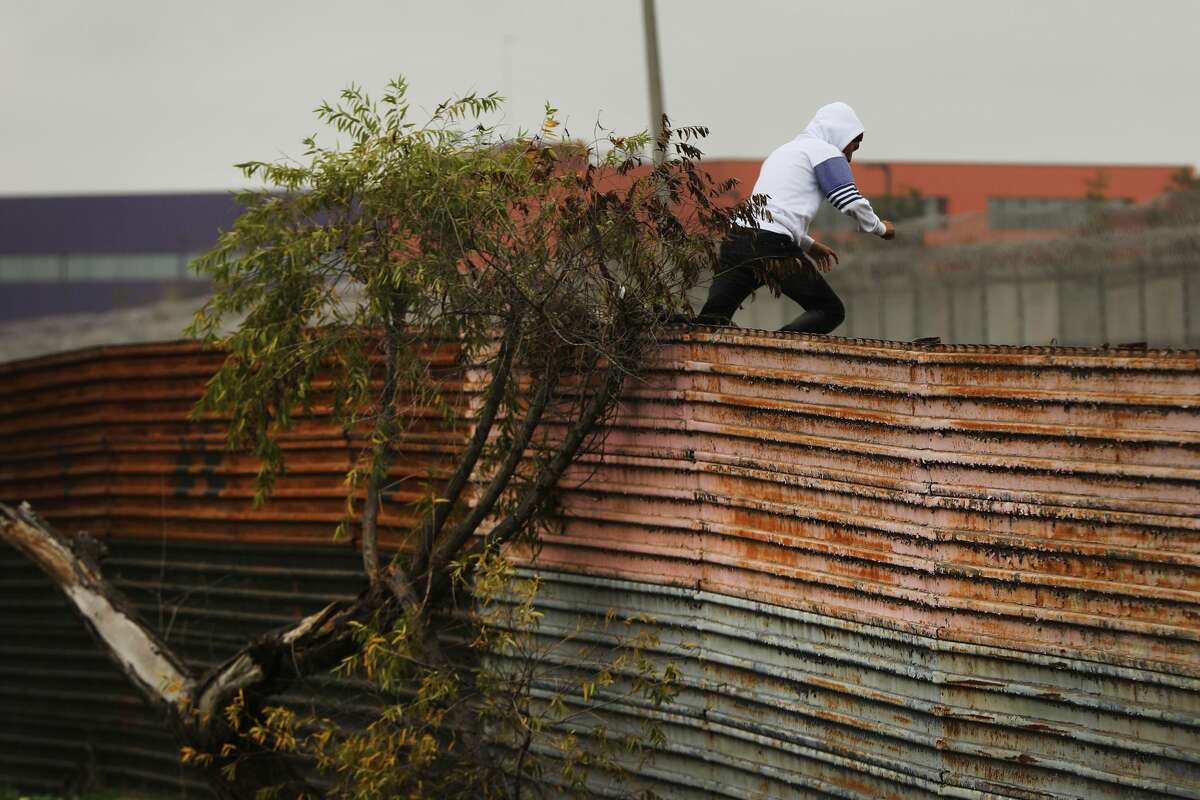 A man jumps over a border fence before surrendering to Border Patrol agents on Jan. 17, 2019 in Tijuana, Mexico. Democrats have rejected the president's latest offer as "hostage taking," saying they would negotiate on border security once the government reopened.