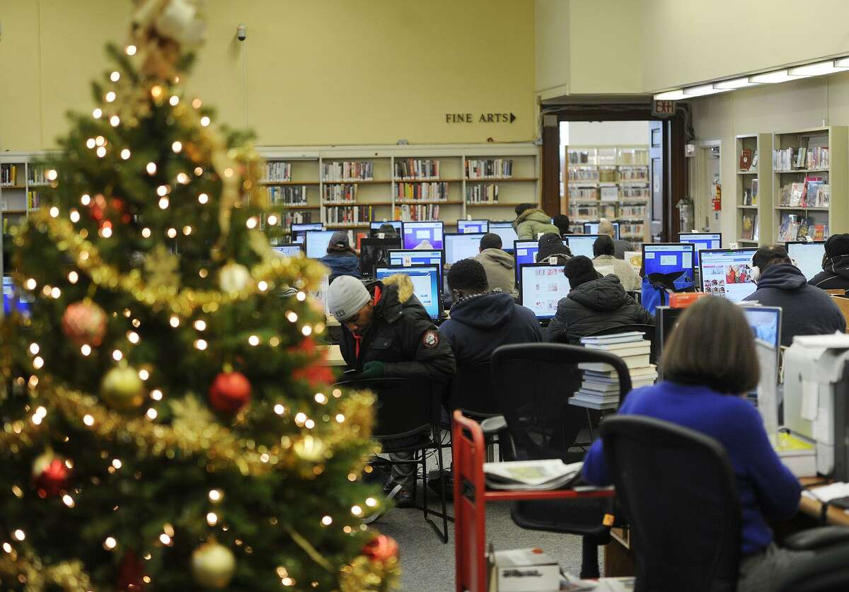 FILE PHOTO — The Bridgeport Public Library's computer access area is crowded as people stay in out of the cold in Bridgeport, Conn. on Wednesday, December 27, 2017. City libraries, senior centers, and the Greater Bridgeport Transit Terminal are open as warming centers as part of the city's cold weather protocol.