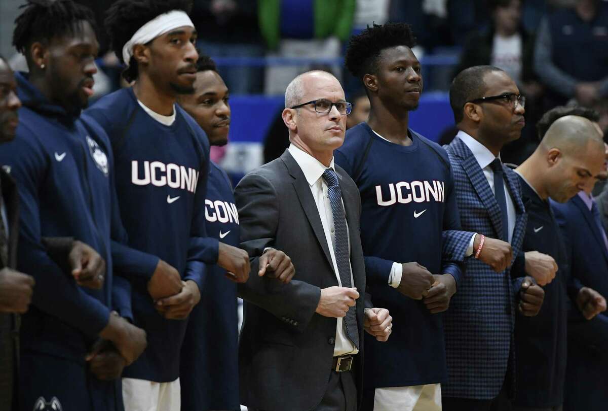 Connecticut head coach Dan Hurley stands with players during the national anthem before an NCAA college basketball game, Sunday, Dec. 2, 2018, in Hartford, Conn. (AP Photo/Jessica Hill)