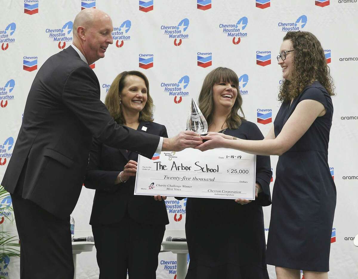 Wade Morehead gives Emily Grichuk of Arbor School a statue as she and JuliAnna Jelinek receive a $25,000 donation from Chevron's Liz Schwarze during the Chevron Houston Marathon charity check passing at the George R. Brown Center on Friday, Jan. 18, 2019 in Houston.