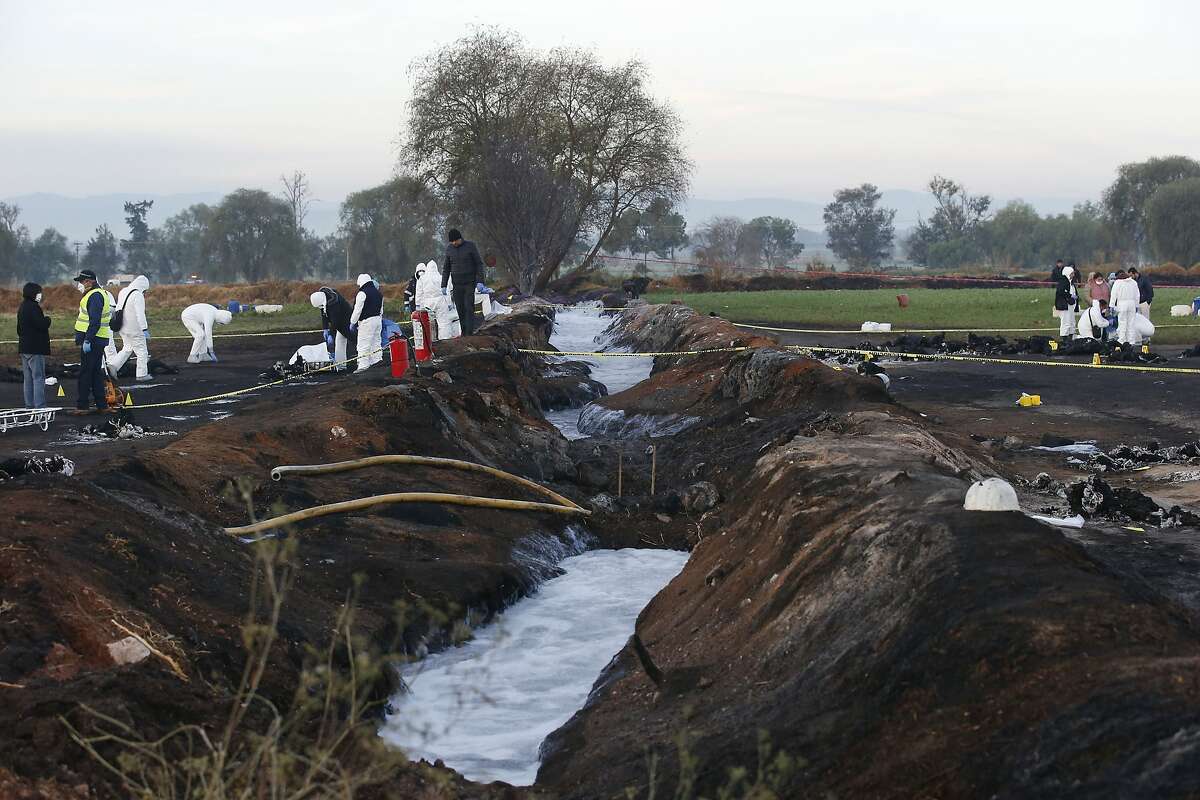 Forensic experts working in the area an oil pipeline explosion in Tlahuelilpan, Hidalgo state, Mexico, Saturday, Jan. 19, 2019. A massive fireball that engulfed people scooping up fuel spilling from a pipeline ruptured by thieves in central Mexico killed dozens of people and badly burned many more. (AP Photo/Claudio Cruz)