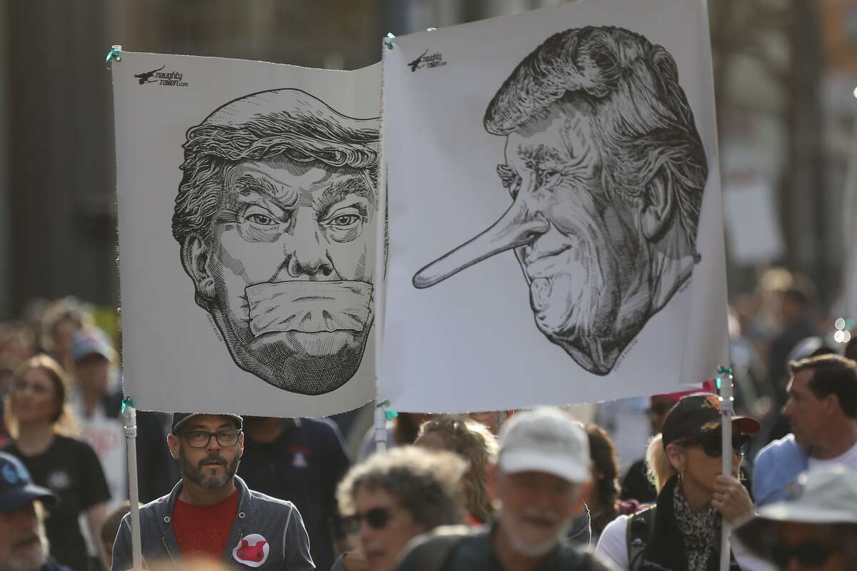 People hold posters of Donald J. Trump as they march along Market St. during the Women’s March, in San Francisco, Calif., on Saturday, January 19, 2019. The event brought thousands of people to the city for a march aimed at push back against Trump and his policies and to remind people of the political power of women.
