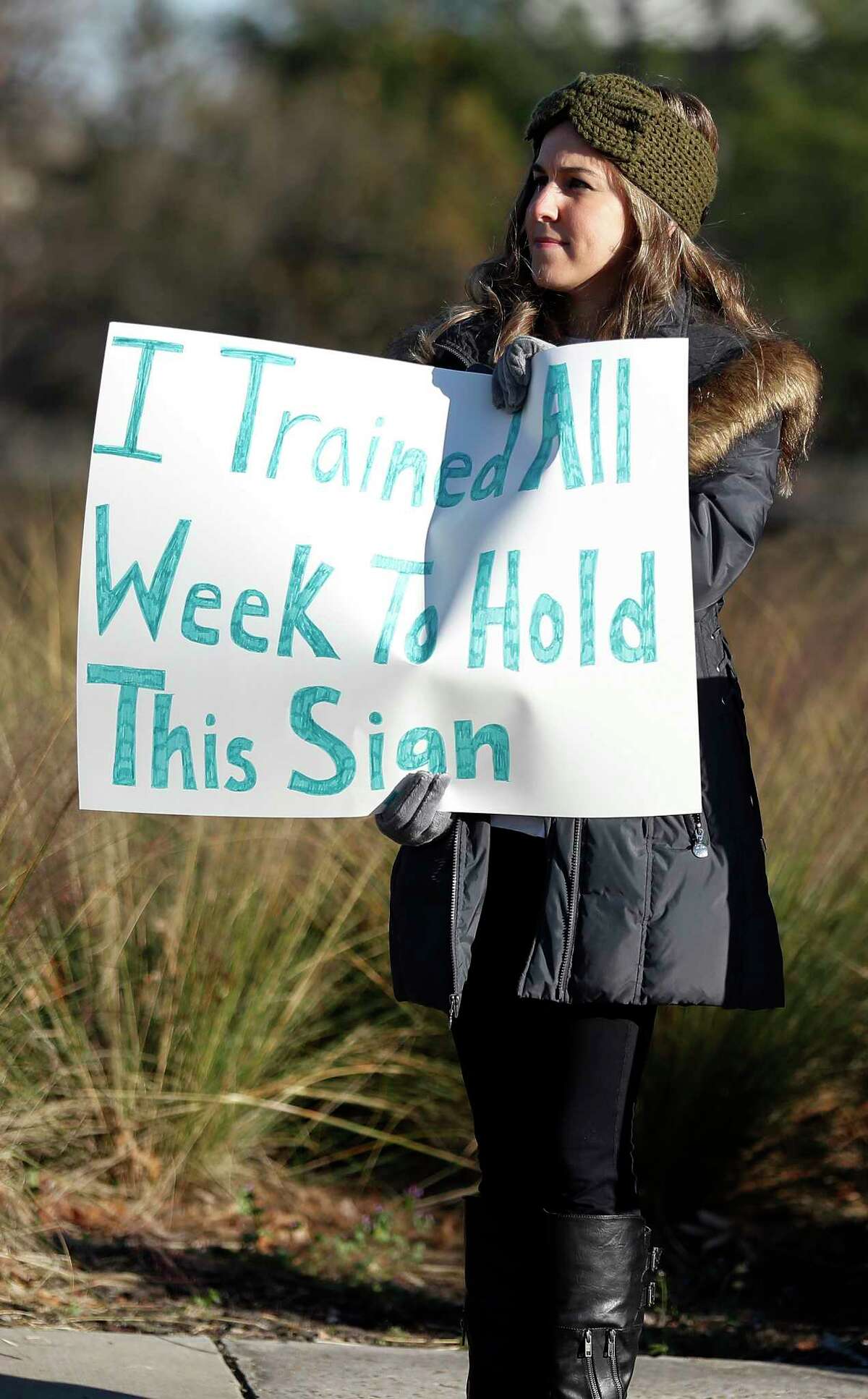 A Half-marathon supporter holds a sign to cheer on runners near mile marker 11 at Montrose and Allen Parkway during the Chevron Houston Marathon, Sunday, Jan. 20, 2019, in Houston.