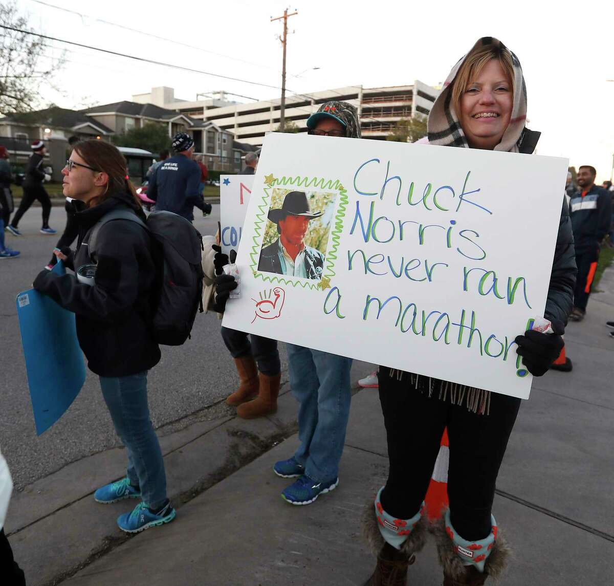 Supporters cheer on runners with signs on Washington Avenue during the Chevron Houston Marathon, Sunday, Jan. 20, 2019, in Houston.