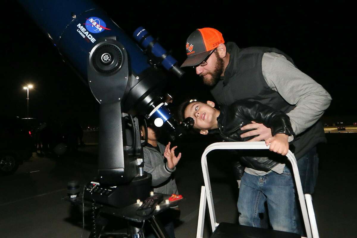 Stuart Cary helps his son, Kaleb Matthey Carw, 4, look at Mars through a Meade LX200 telescope during an lunar eclipse-watch party at the Scobee Education Center at San Antonio College on Sunday, Jan. 20, 2019. The total lunar eclipse tonight is being called the "super blood wolf moon."