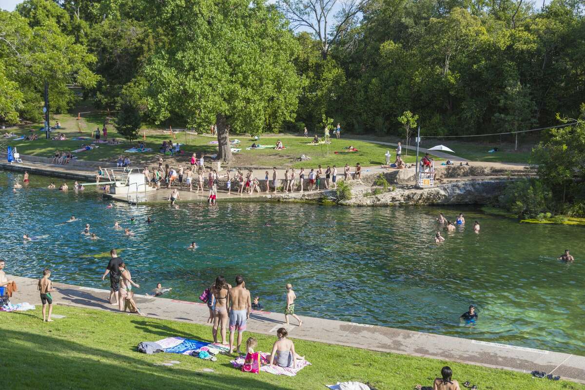 Swimmers on a hot day in Barton Springs Pool. Barton Springs Pool is a man-made recreational swimming pool located on the grounds of Zilker Park in Austin, Texas. The pool exists in the channel of Barton Creek and is filled by water from Main Barton Spring, the fourth largest spring in Texas.