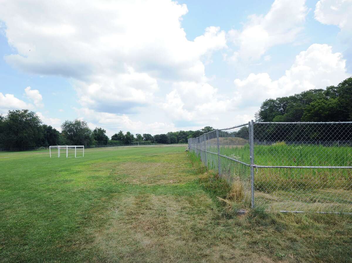 The athletic fields, open at left, close at right due to toxicity issues with chemicals in the soil, at Western Middle School in Greenwich, Conn. Wednesday, July 11, 2018. Part of Western's fields reopened for student use in September 2017, but a large portion, including the softball field has remained closed and fenced off since August 2016, when high levels of PCBs, arsenic, lead and chlordane were found in the soil.