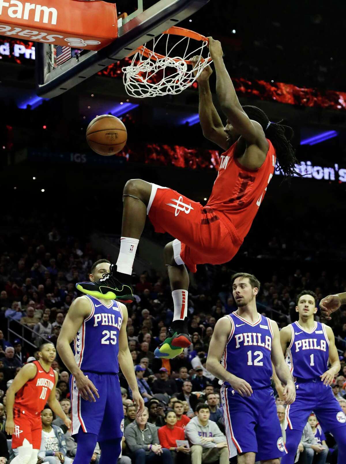 Houston Rockets' Kenneth Faried (35) dunks the ball as Philadelphia 76ers' Ben Simmons (25) , T.J. McConnell (12) and Landry Shamet (1) look on during the first half of an NBA basketball game, Monday, Jan. 21, 2019, in Philadelphia. (AP Photo/Matt Slocum)