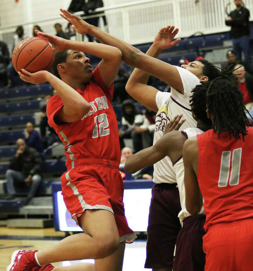 Alton’s Josh Rivers (left) draws a foul on a Soldan defender on a shot in the lane in the fourth quarter Monday night in fourth annual SLUH/MLK Classic in St. Louis. The Redbirds won 75-71 in overtime. Photo: Greg Shashack / The Telegraph
