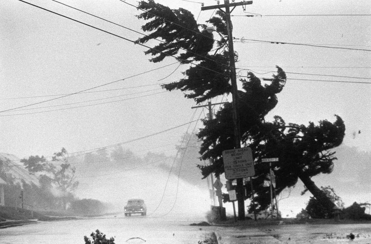 Waves from Long Island Sound break over a car stopped by power lines brought down by the tree on New Haven Avenue in Milford, CT, as Hurricane Gloria struck the Conneticut shoreline, 9/27.