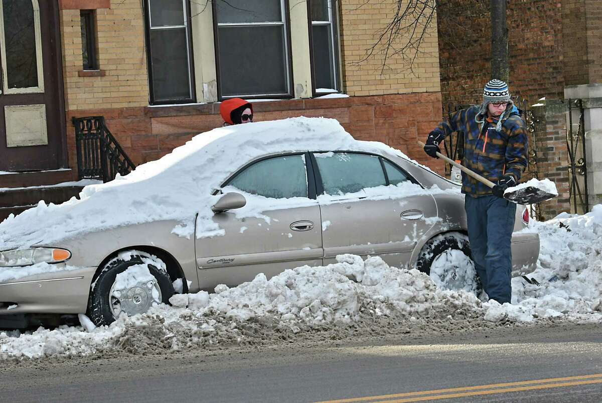 Will Behan of Albany, right, and his girlfriend Shea Stoughton dig out of a parking spot on Madison Ave. on Tuesday, Jan. 22, 2019 in Albany, N.Y. The couple wanted to move their car for the snow emergency after a major snowstorm on Sunday. (Lori Van Buren/Times Union)