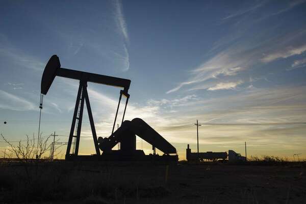 A tanker truck drives past a pump jack in the Permian Basin area of Loving County, Texas, U.S., on Saturday, Dec. 15, 2018. Once the shining star of the oil business, gasoline has turned into such a drag on profits that U.S. refiners could be forced to slow production in response. Photographer: Angus Mordant/Bloomberg