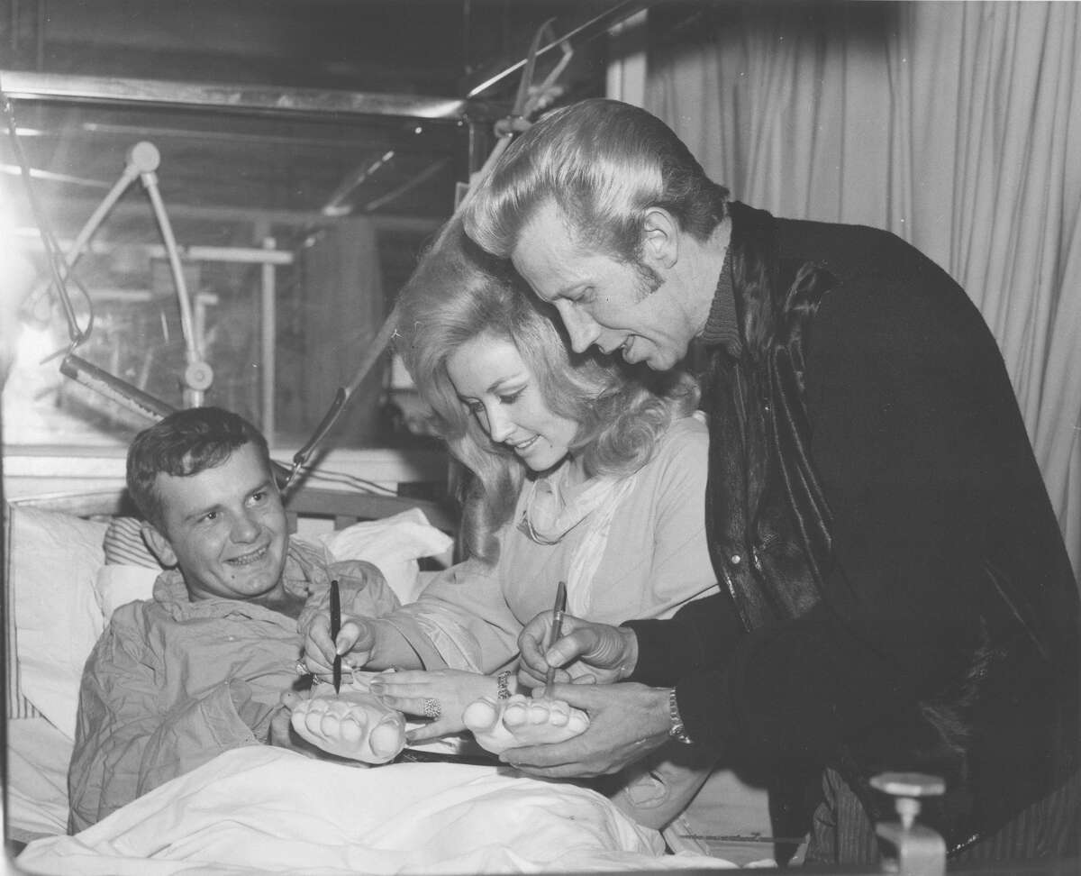 Dolly Parton and Porter Waggoner, who were performers at the 1970 Stock Show & Rodeo, visit a hospital patient while in San Antonio.