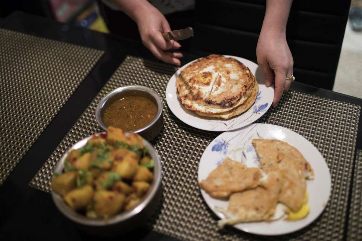 Rachana Shakya, 30, serves Baara and spiced potatoes, both Newari dishes at her home in Houston on Tuesday, Jan. 15, 2019.