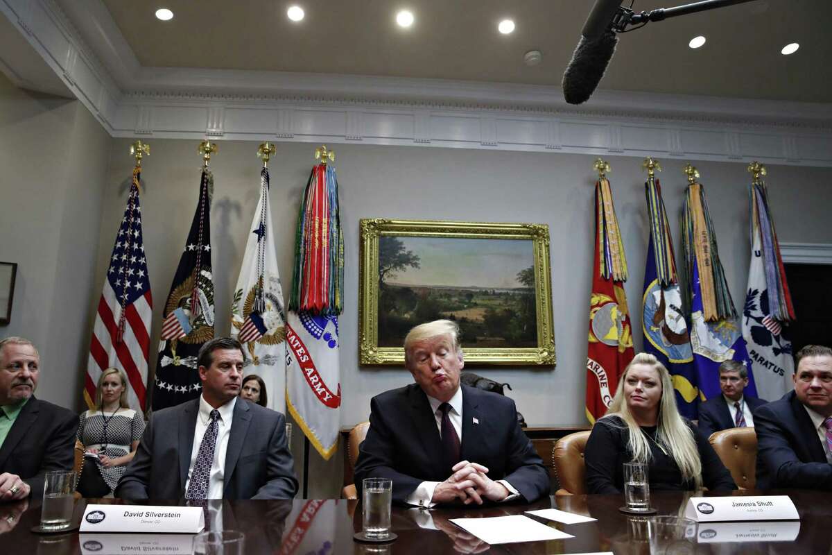President Donald Trump, center, reacts as he is told by a reporter that House Speaker Nancy Pelosi said the Democratically controlled House won’t pass the required measure for him to make the State of the Union address at the Capitol until after the government is fully opened. With the president for a healthcare roundtable discussion Wednesday are David Silverstein, of Denver, left, and Jamesia Shutt, of Aurora, Colo., right.
