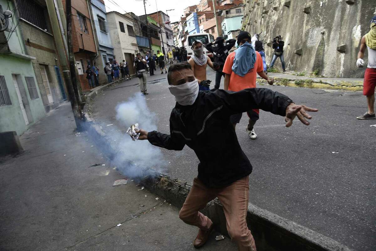 A demonstrator throws back a tear gas canister during a protest in the Cotiza neighborhood of Caracas, Venezuela, on Jan. 21, 2019.