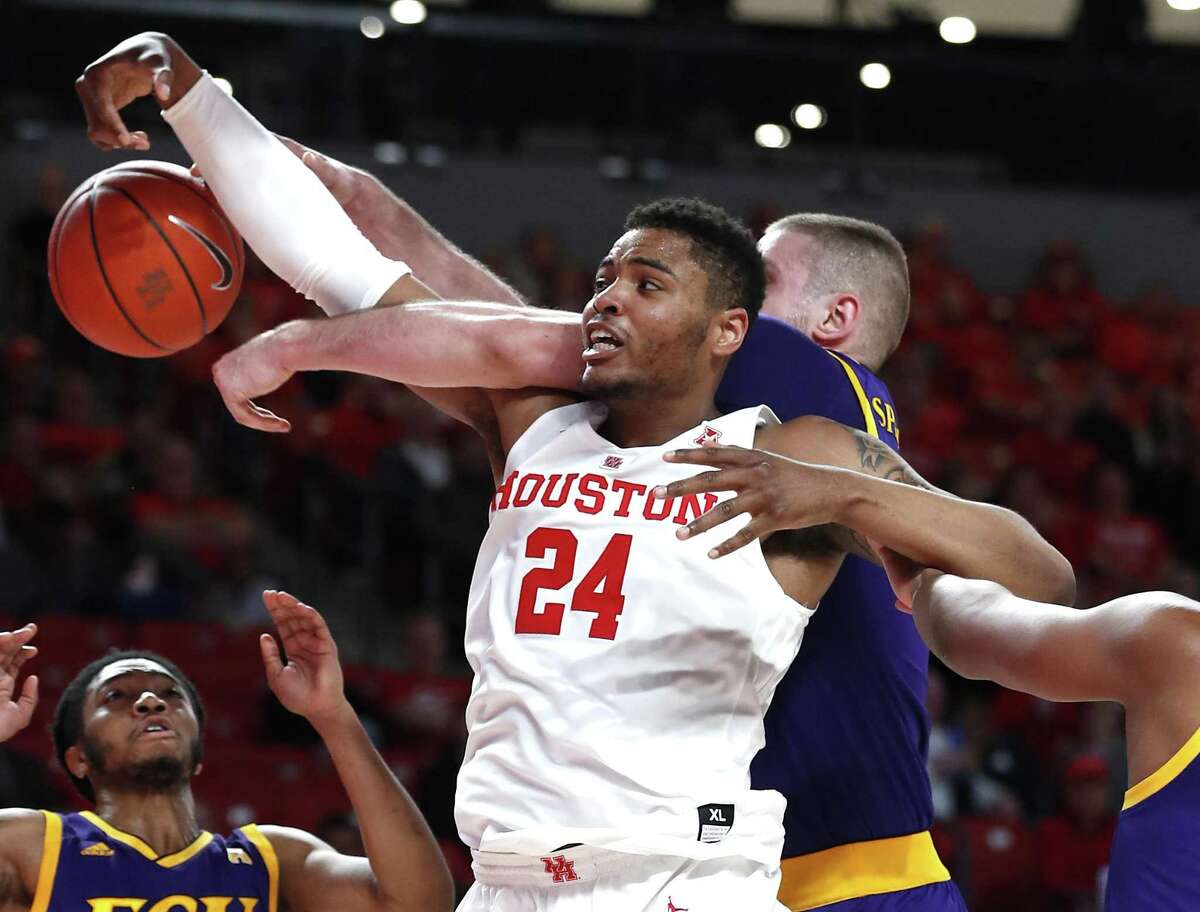 Houston forward Breaon Brady (24) gets tangled up with East Carolina forward Dimitrije Spasojevic going for a rebound during the first half on a NCAA basketball game at Fertitta Center on Wednesday in Houston.
