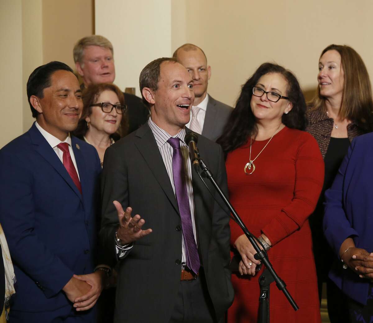 Assemblyman Brian Maienschein, center, discusses his decision to switch party registration from Republican to Democrat at a news conference, Thursday, Jan. 24, 2019, in Sacramento, Calif. Maienschein was flanked by Democratic Assembly members, from left, including Todd Gloria of San Diego, Eloise Gomez Reyes, of San Bernardino, Mark Stone of Scotts Valley, Kevin McCarty of Sacramento, Lorena Gonzalez Fletcher of San Diego and Jacqui Irwin, of Thousand Oaks. (AP Photo/Rich Pedroncelli)