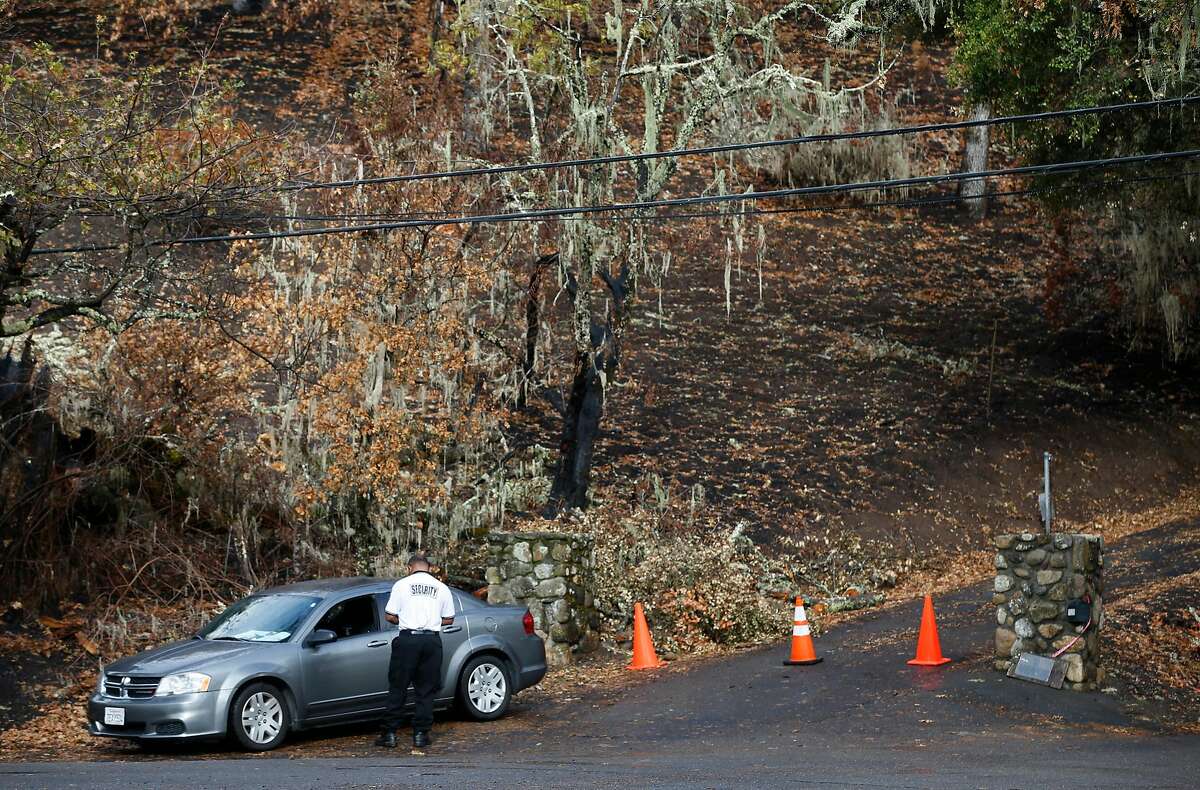 A security guard blocks the entrance to a home on Bennett Lane in Calistoga, Calif. on Friday, Nov. 10, 2017 where investigators believe is the origin of the Tubbs Fire. PG&E filed legal papers suggesting that third party electrical equipment, not theirs, may have been the cause of last month's deadly Tubbs Fire.