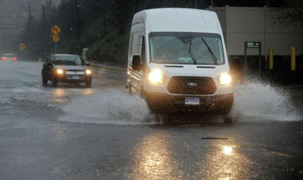 Motor vehicles drives through a flooded street on Glover Ave. during the rainstorm Thursday, January 24, 2018, in Norwalk, Conn.