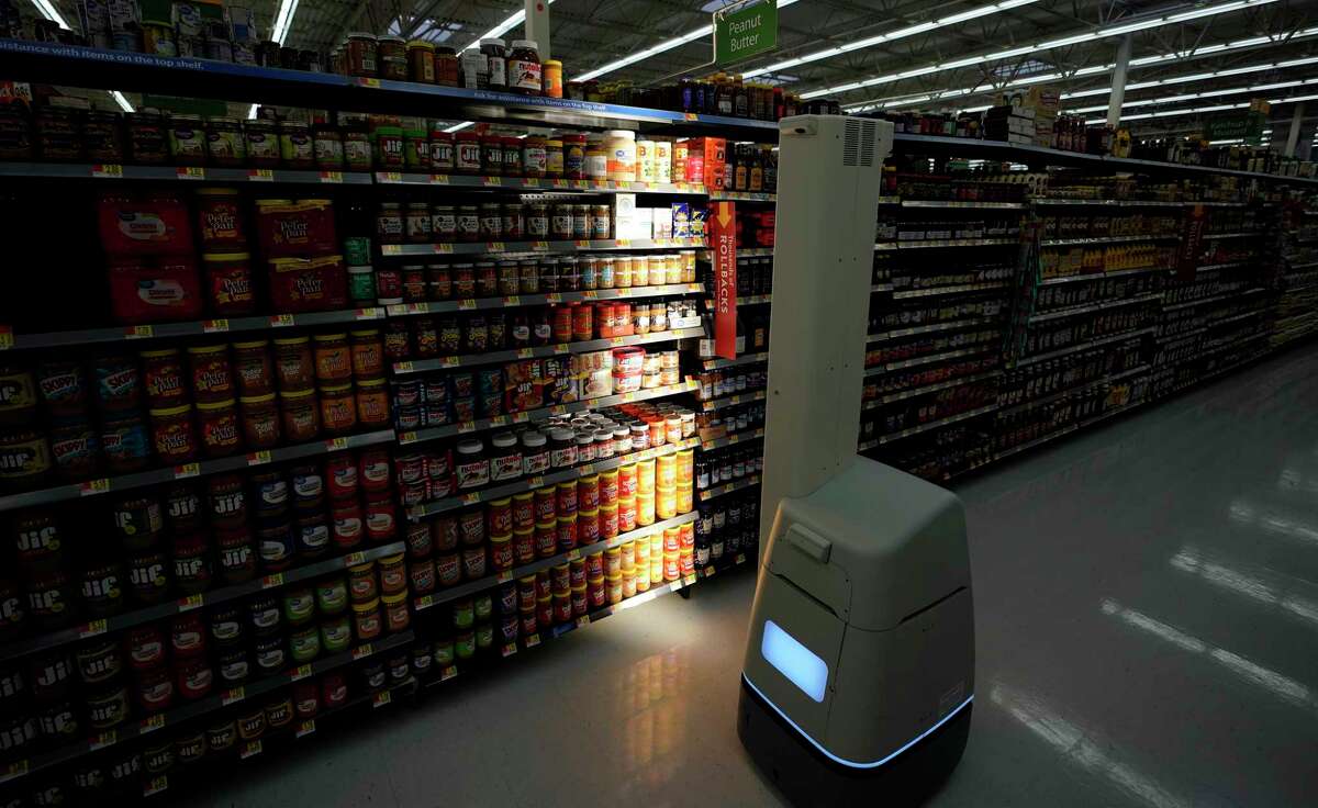 FILE - In this Nov. 9, 2018, file photo, a Bossa Nova robot scans shelves to help provide associates with real-time inventory data at a Walmart Supercenter in Houston. Robots aren?’t replacing everyone, but a quarter of U.S. jobs will be severely disrupted as artificial intelligence accelerates the automation of today?’s work, according to a new Brookings Institution report. The report published Thursday, Jan. 24, 2019, says roughly 36 million Americans hold jobs with ?“high exposure?” to automation, meaning about 70 percent of their work tasks could soon be performed by machines using current technology. (AP Photo/David J. Phillip, File)