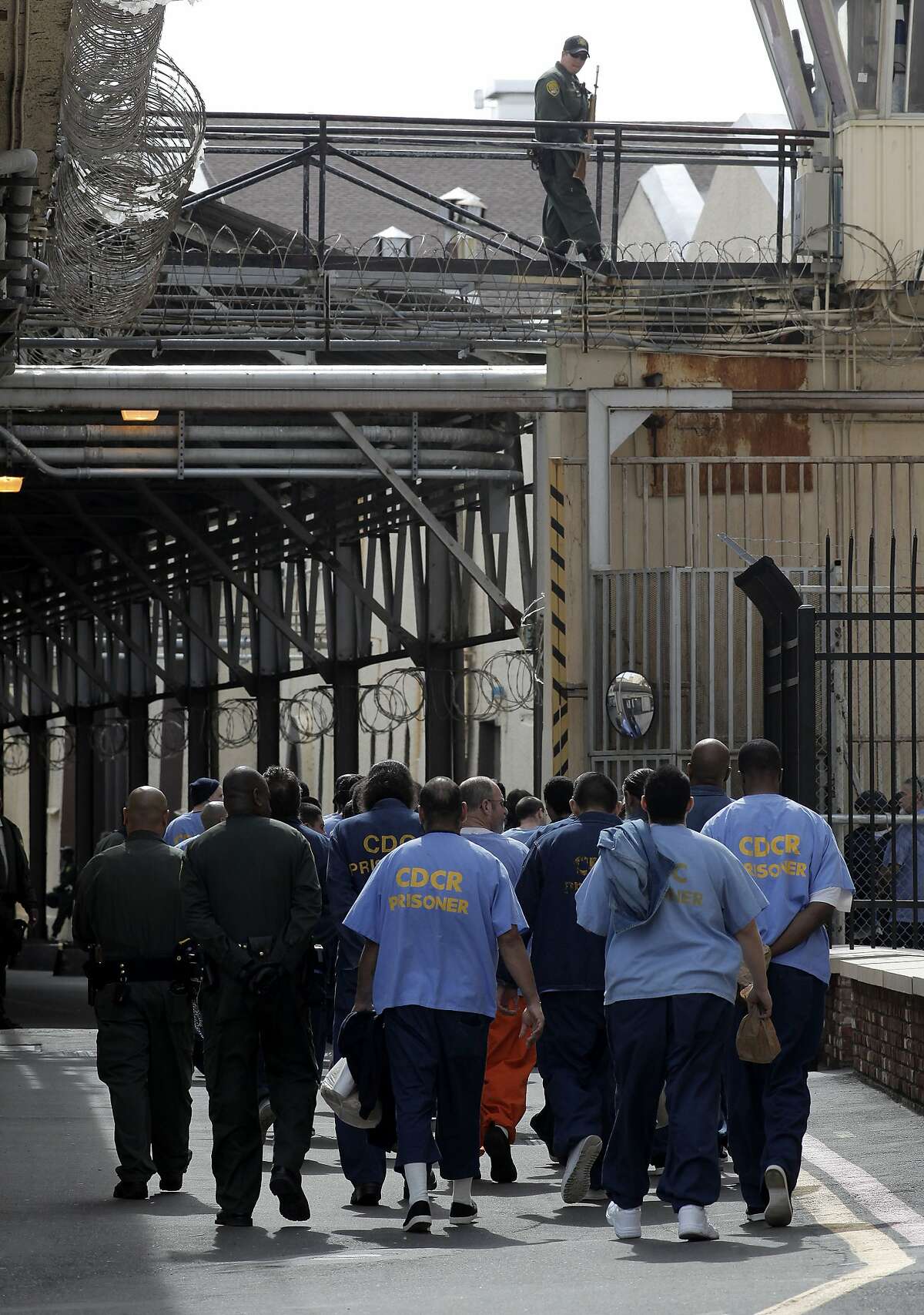 Corrections officers, lead prisoners back to their housing inside San Quentin State Prison, on Friday Mar. 4, 2011, in San Quentin, Calif. California state prison guards and their supervisors, have racked up an astounding 33 million hours of vacation, sick and other paid time off, which could amount to as much as a $1 billion liability for the state. A Senate report warned, a year ago, that mandatory furloughs at a 24-7 agency, would lead to such future burdens.