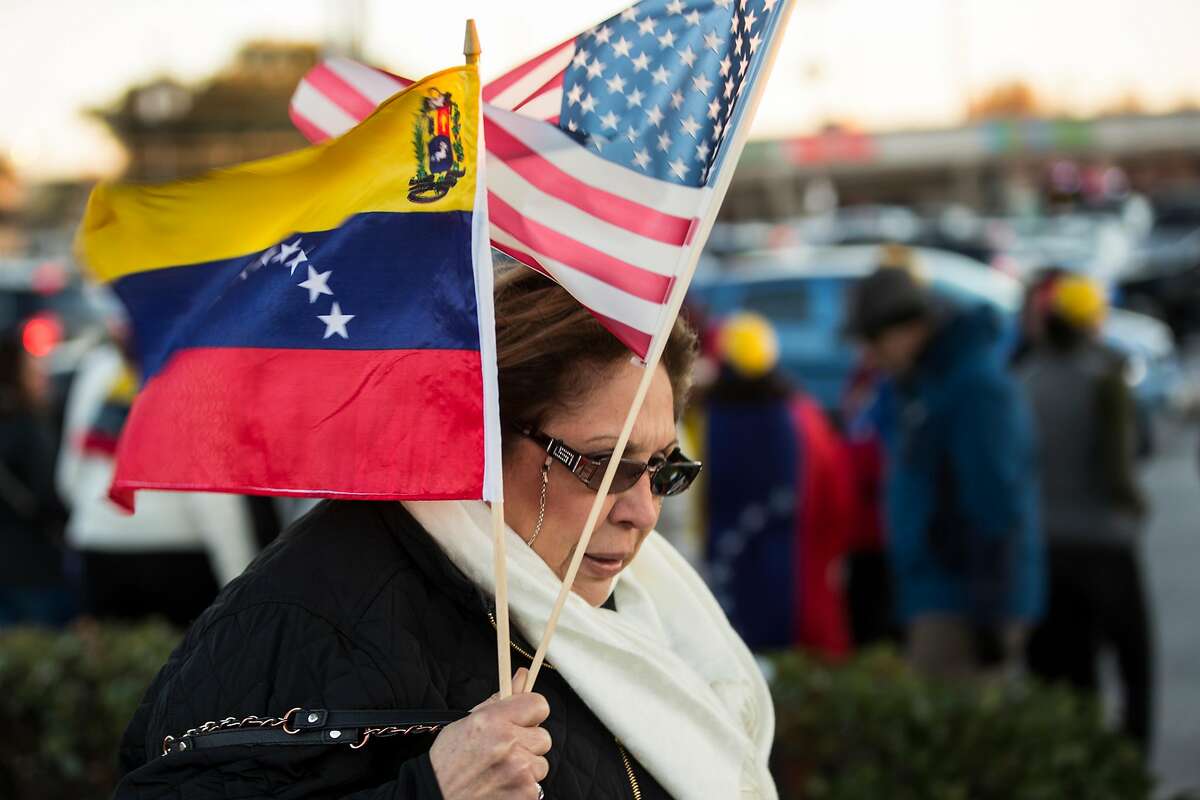 Carmen Nino carries a Venezuelan flag and an American flas she she joins local Venezuelans to demonstrate in reaction to recent political happenings in their home country on Wednesday, Jan. 23, 2019, in Houston. The demonstrators are gathering in support of Opposition leader Juan Guaido, who swore himself in as President of Venezuela, and against President Nicol�s Maduro. President Trump announced today that he is recognizing Venezuelan opposition leader.