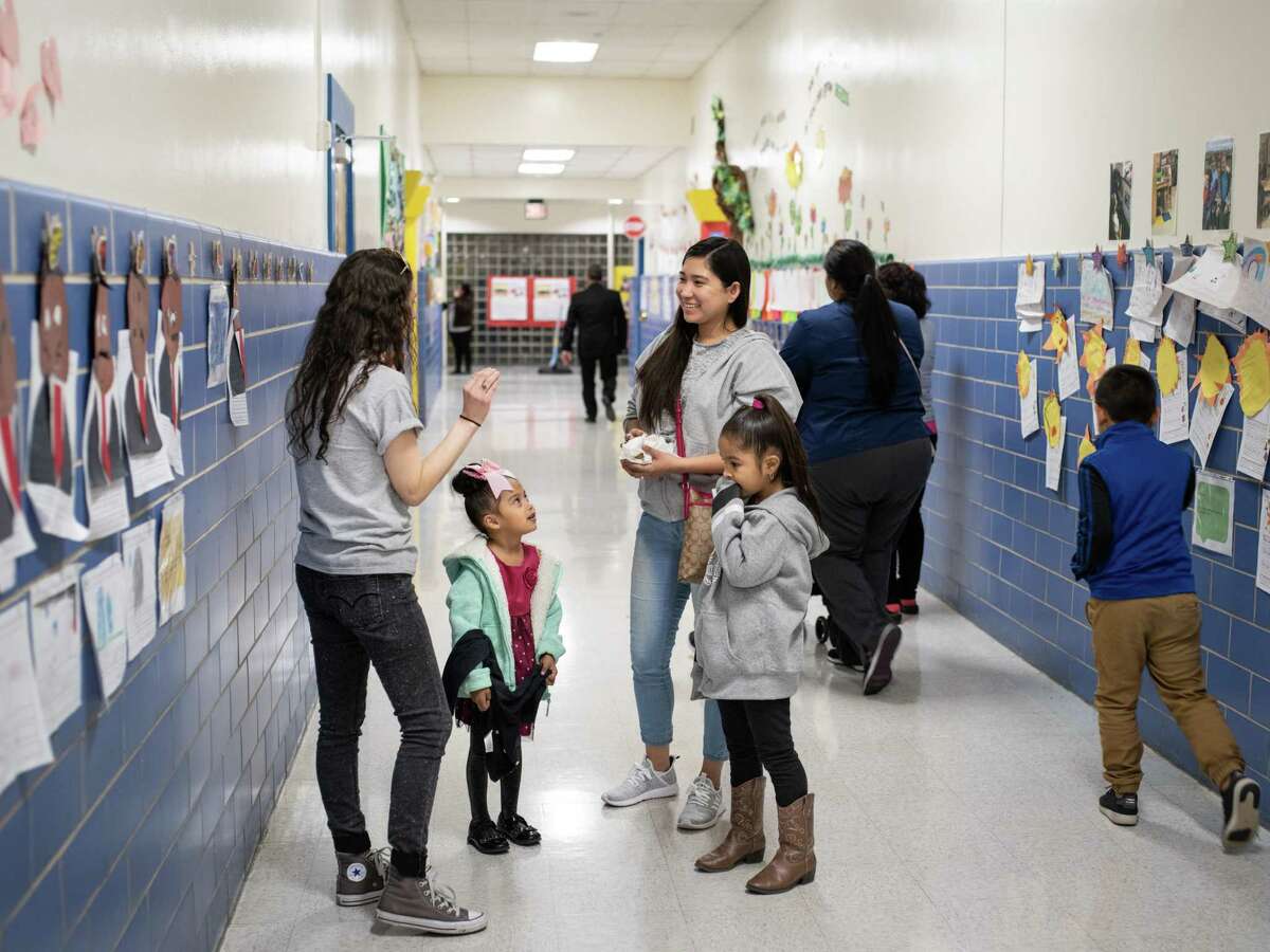 Krystal Olivarez and her daughters Krista Olivarez, 4, left, and Kaylee Olivarez, 6, at right, talk with Krista's Pre-K teacher Keleigh Perry, left, during an event last month at Gardendale Elementary School introducing parents and their children to the proposed partnership between the Edgewood ISD school and Pre-K 4 SA.