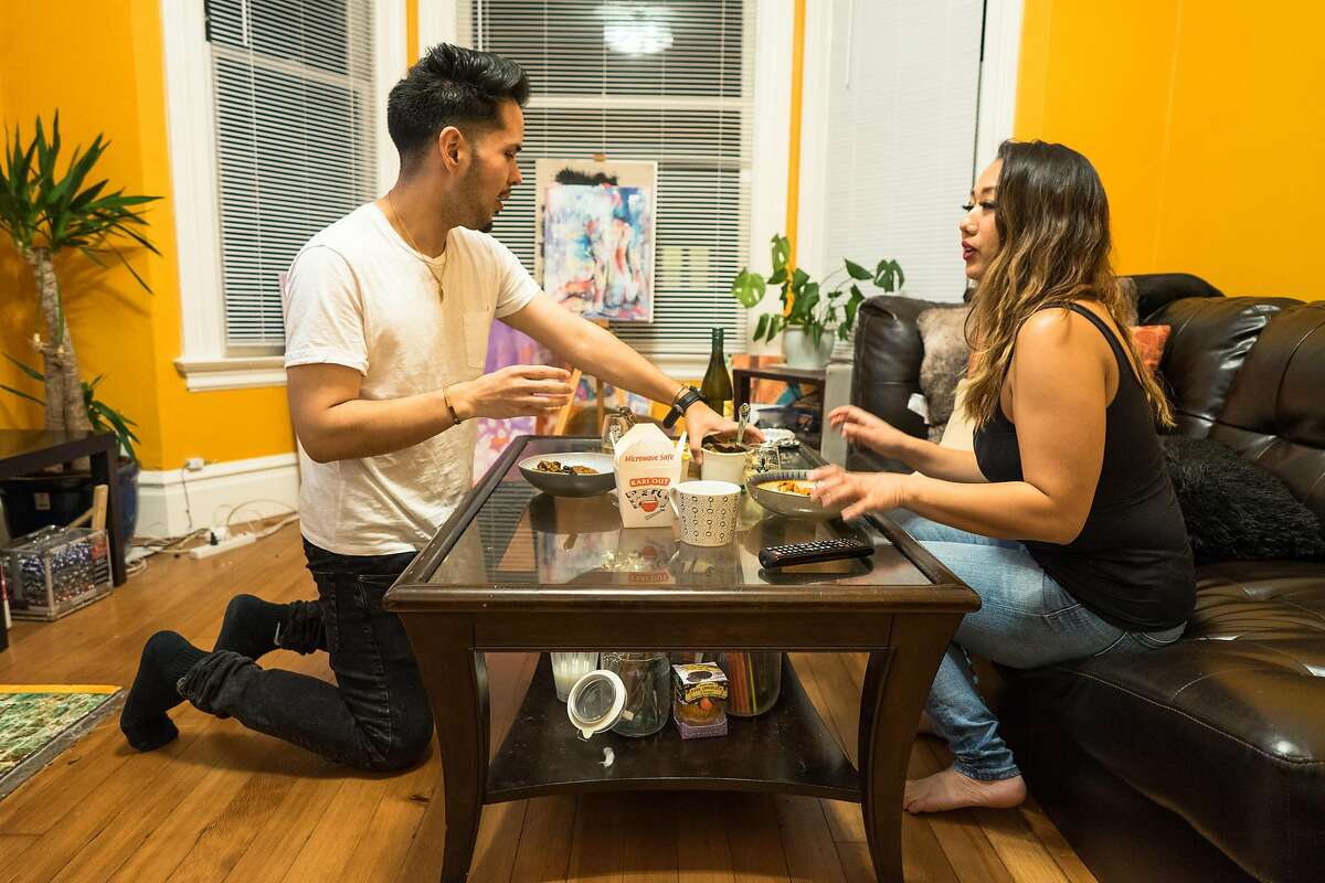 Stephen Torres-Esquer and his roommate Emerald Law split dinner before watching television at their apartment in San Francisco, Calif. on Thursday, Jan. 24, 2018. The city is trying to decide whether to spend $184 million dollars in windfall money on the homeless or teachers. Teachers like Torres-Esquer is barely making ends meet in the city and may return home to Stockton.