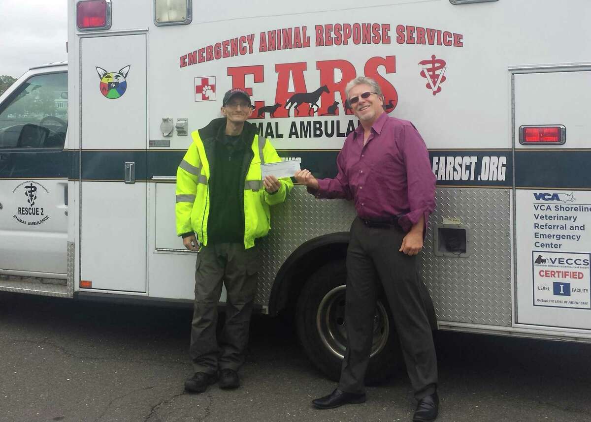 Westport Weston Chamber of Commerce President Matthew Mandell, right, presents a check to Jon Nowinski from the Emergency Animal Response Service (EARS).