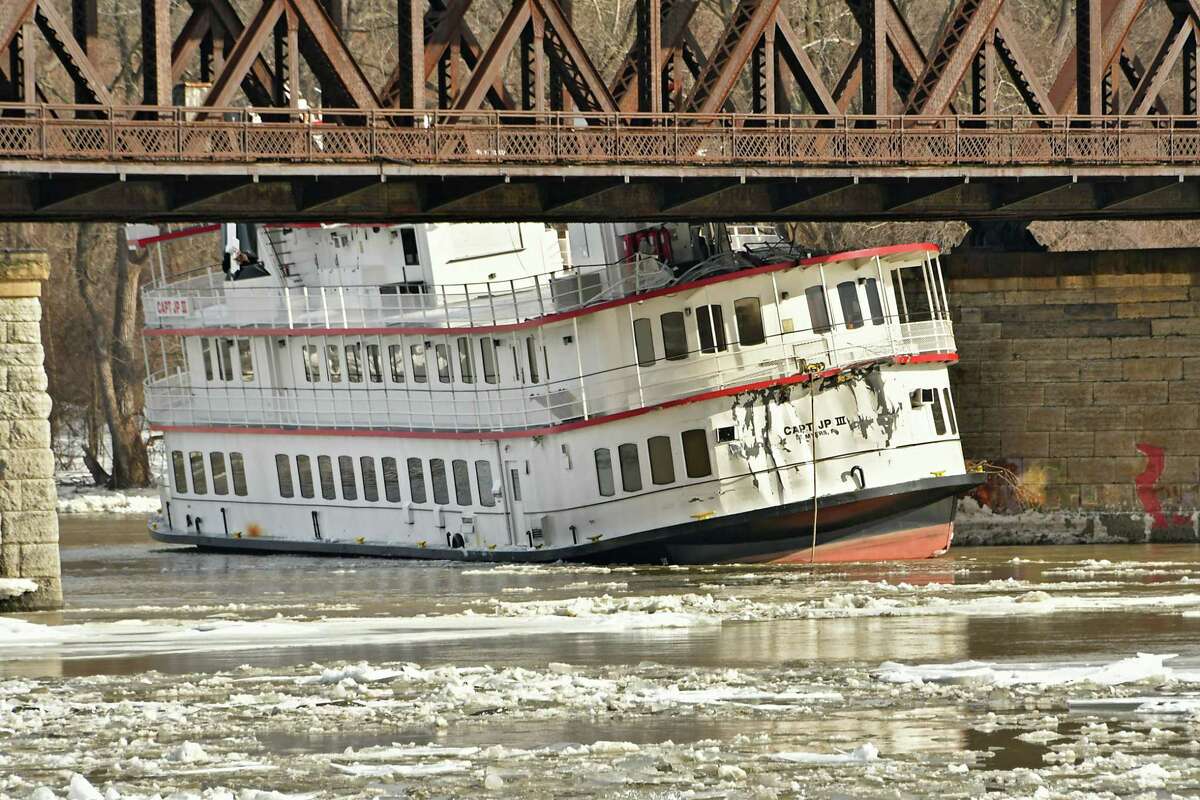The Captain JP lll boat is seen stuck under the railroad bridge near the Corning Preserve on the Hudson River on Friday, Jan. 25, 2019 in Albany, N.Y. The boat, along with other barges including the Rusty Anchor, broke from the dock in Troy from the fast moving ice on the Hudson River. (Lori Van Buren/Times Union)