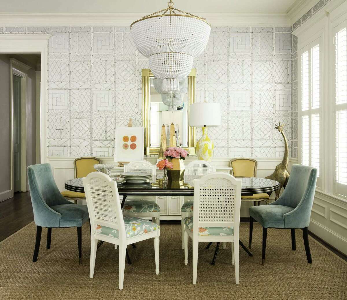 With blue and yellow upholstery carrying the color scheme of the rest of the house, the dining chairs don’t appear mismatched. The "Jacqueline" two-tier chandelier is from Circa Lighting.