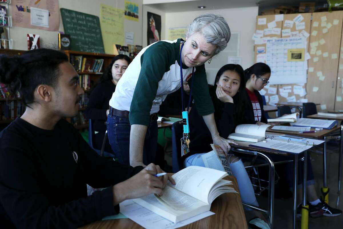 Lara Trale, an English teacher for 12 years at Oakland High School, listens to tenth grade student Kevin Alvarenga, 15, as they go over a lesson during their tenth grade English in the Environmental Science Academy at Oakland High School, in Oakland, Calif., on Thursday, January 24, 2019. Oakland public school teachers have been working without a contract since July 2017. Negotiations on a new contract have gone on so long that teachers have threatened a citywide strike. The strike vote will happen Jan. 29-Feb. 1. After the success of the Los Angeles public school teachers strike, it looks like Oakland is headed for one if the school district doesn't budge. And the teachers are ready.
