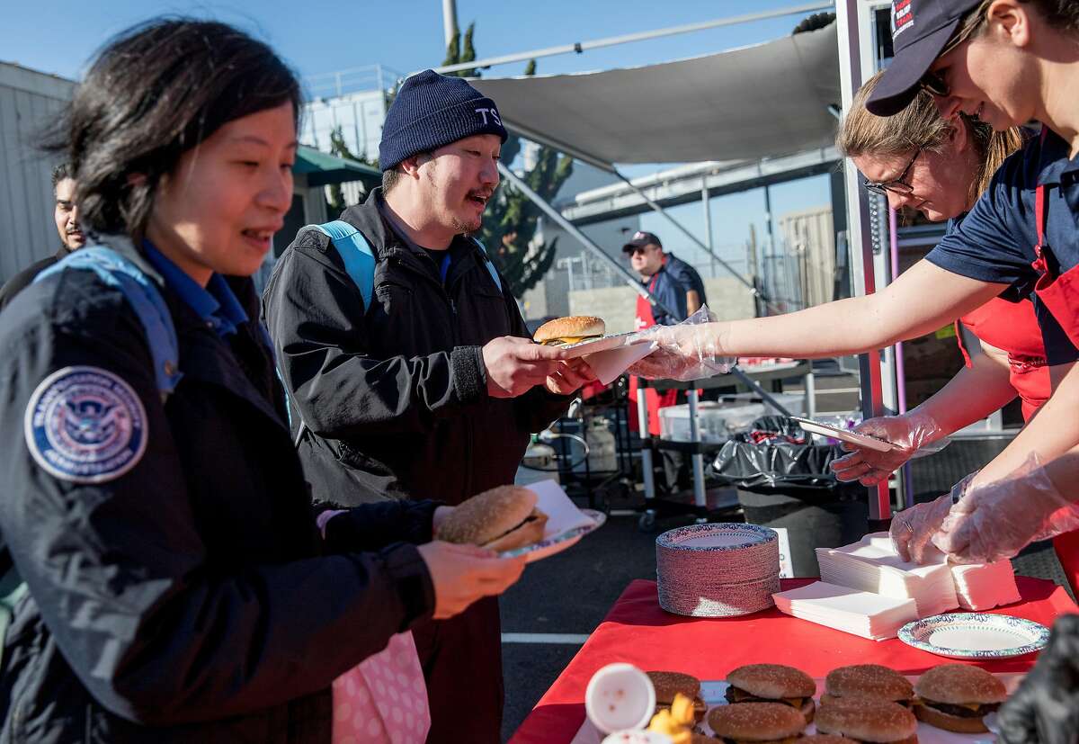 Oakland International Airport TSA Agents Nancy Huang (left) and Andrew Butler receive lunch from the Rapid Relief Team while at the Oakland International Airport in Oakland, Calif. Friday, Jan. 25, 2019 after the government shutdown has forced federal workers to miss their second paycheck.