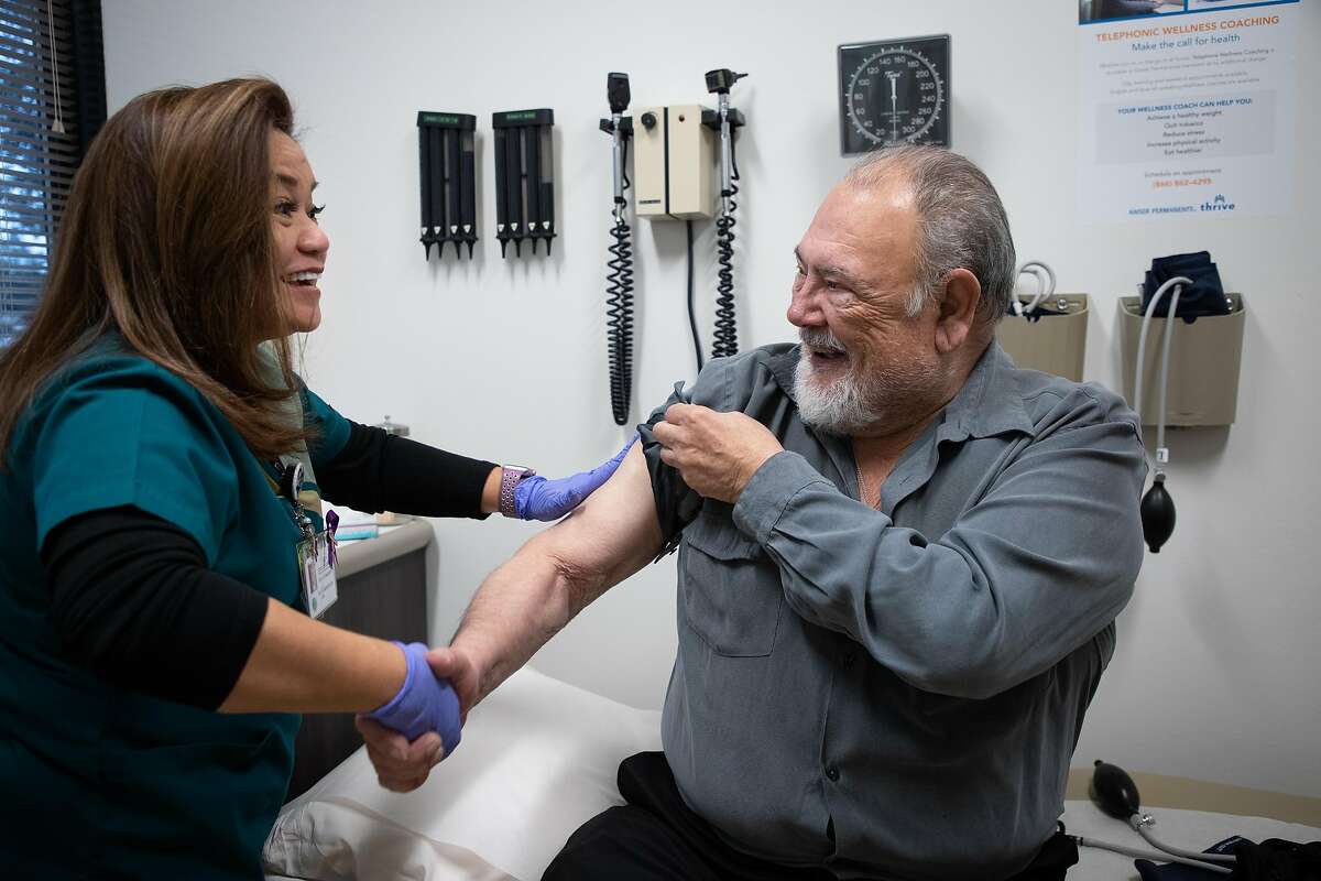 Ilda Villahermosa shakes congratulates Eugene Thiers, 77, of San Mateo, after administering a flu shot to him at Kaiser Permanente Redwood City on Monday, Jan. 14, 2019, in Redwood City, Calif.