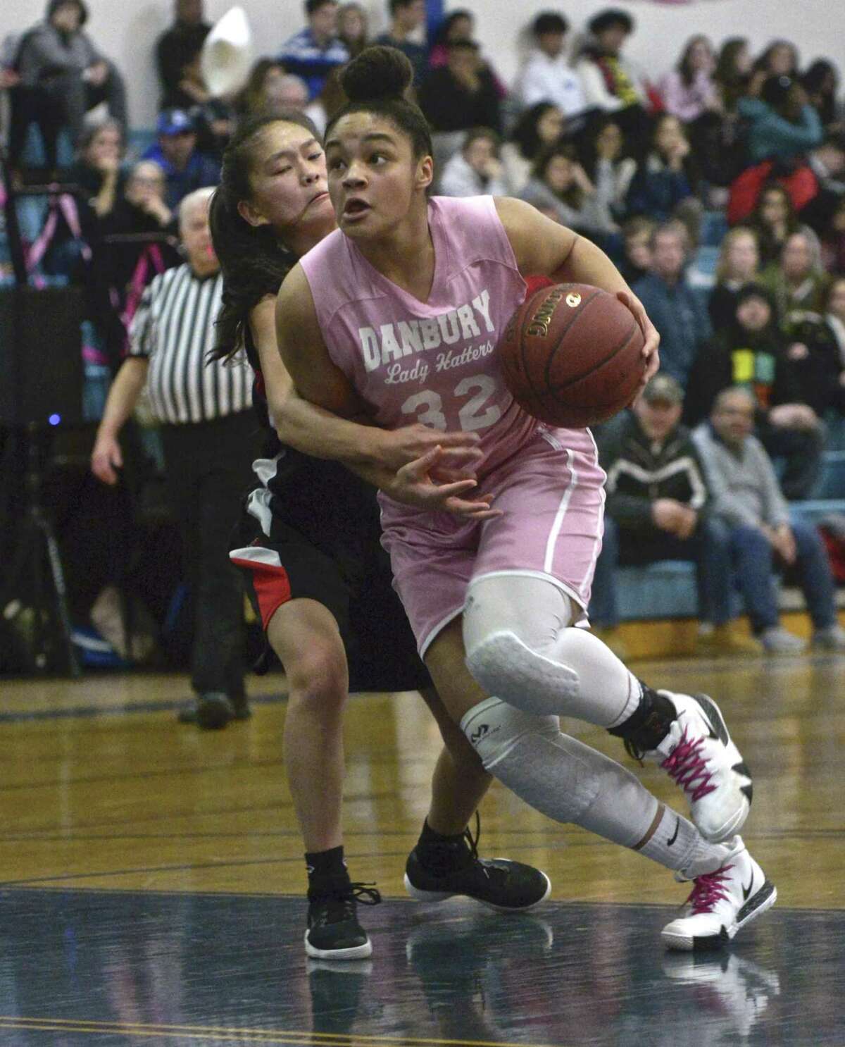 Danbury's Kianna Perry (32) drives past Warde's Ava Fitzpatrick (4) in the girls basketball game between Fairfield Warde and Danbury high schools, Friday night, January 25, 2019, at Danbury High School, Danbury, Conn.