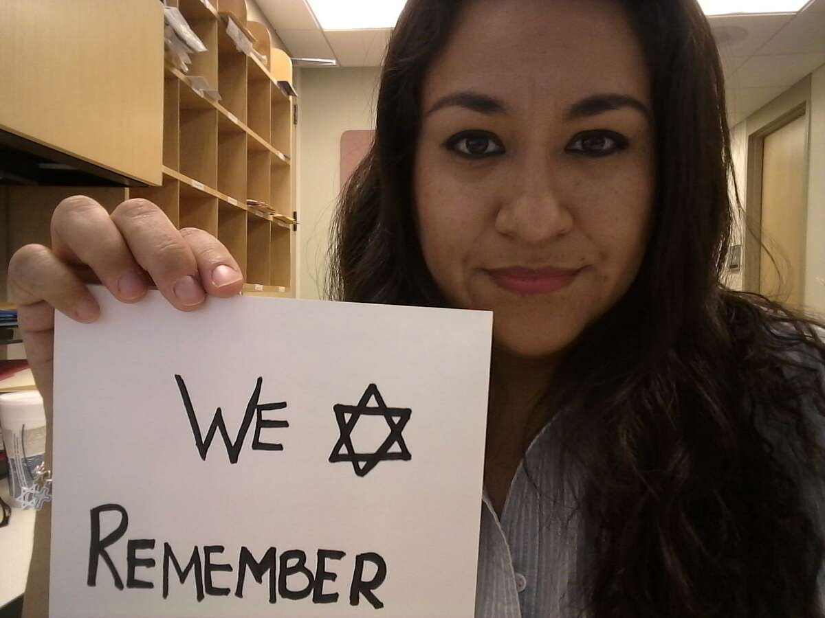 Barbara Gutierrez-Flores, from Houston, holds a sign reading #WeRemember with which she joined a social media campaign with the same hashtag commemorating the International Holocaust Remembrance Day 2018.