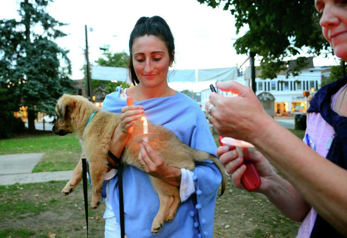 While holding her dog Harley, Jacqueline Willsey, of Fairfield, takes part in a candlelight vigil by Fairfield Cares as part of National Overdose Awareness Day at the Sherman Green gazebo in Fairfield, Conn., on Friday Aug. 31, 2018. Fairfield Cares is a community coalition collaborating among schools, parents, Fairfield town departments and other organizations dedicated to substance abuse prevention.