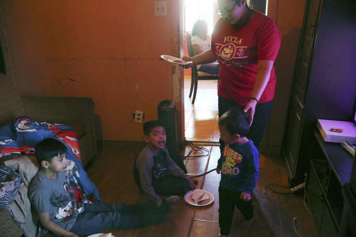 Crystal Guevara-Alvarado, 30, helps her youngest son, Joseph Sanchez, a 19-month-old, with his breakfast as he joins his stepbrothers, Ishmael Alvarado, 8, left, and Samuel Alvarado, 5. Guevara-Alvarado hopes to find new employment, perhaps with the Bexar County Sheriff’s Office, she said.