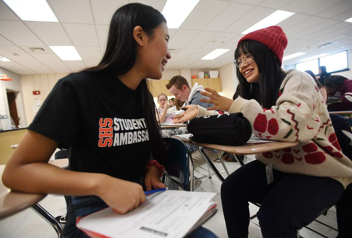 Shelton High student ambassador Seungmin Lee, left, makes fast friends with visiting Chinese student Bonnie Liu during chemistry class at Shelton High School on Tuesday, January 29, 2019. Students from Jian Ping High School, Shelton's sister school in Shanghai, China, shadowed students in their daily classes to get a feel for school life in the United States.