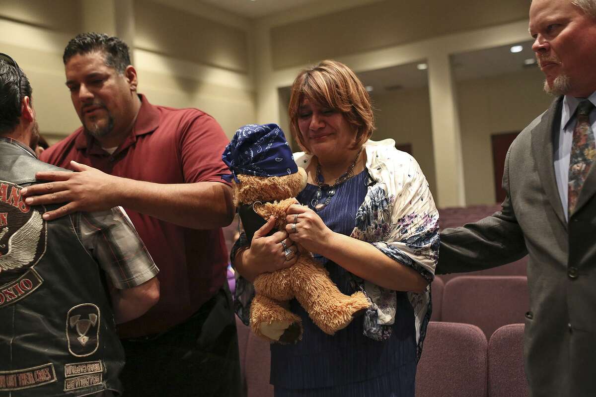 Pamela Allen holds a bear given to her by the Guardians of the Children motorcycle group including president Charles Chacon, far left, who presented Allen with the bear at the conclusion of the funeral for Baby Noel at Summit Christian Center in San Antonio on Saturday, March 22, 2014. Pamela's brother, Samuel Espurvoa, left, and her husband, Tim Allen, right, stand by her side. Pamela worked for months to make sure Baby Noel had a proper funeral and burial.